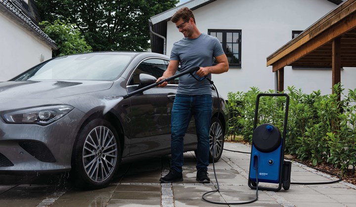 Man cleaning car with high pressure washer