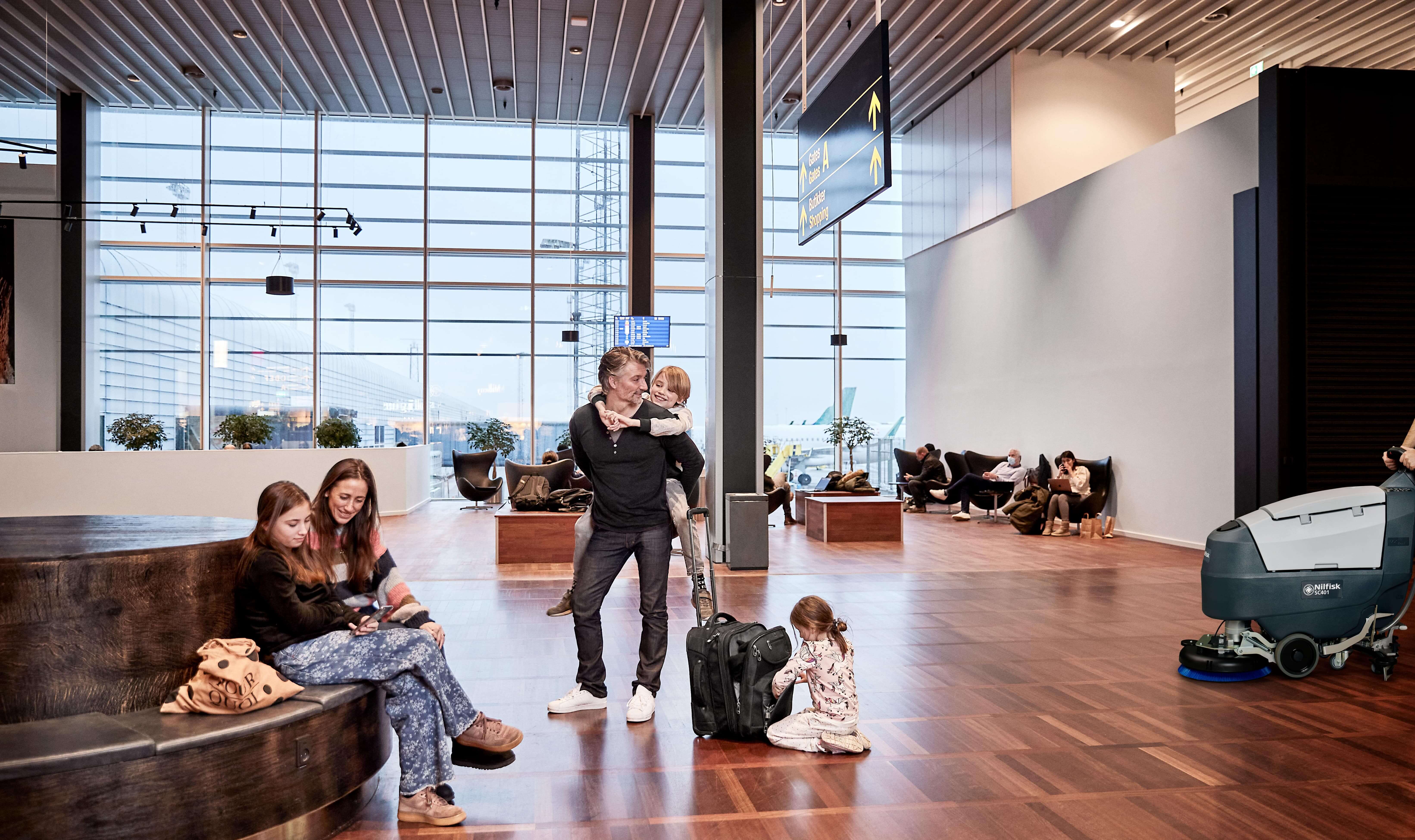 Família no aeroporto com lavadora Nilfisk SC401